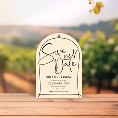 Arch shape flat lay of semi-custom Vino wedding save the date with hand-drawn vineyard-inspired border.