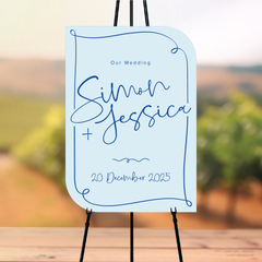 Double Up shape flat lay of semi-custom Vino wedding welcome sign with hand-drawn vineyard-inspired border.