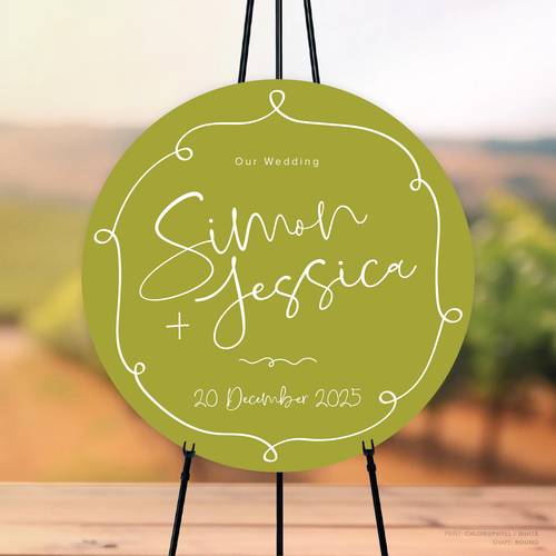 Round shape flat lay of semi-custom Vino wedding welcome sign with hand-drawn vineyard-inspired border.