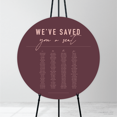 Round shape flat lay of Never Let You Go wedding seating chart featuring bold and delicate typography with modern, expressive layout and semi-custom design.