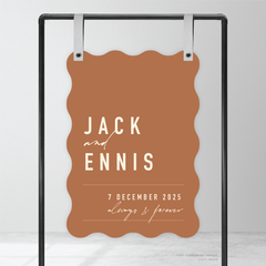 Wave shape flat lay of Never Let You Go wedding welcome sign featuring bold and delicate typography with modern, expressive layout and semi-custom design.