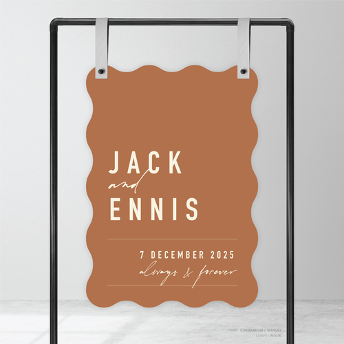 Wave shape flat lay of Never Let You Go wedding welcome sign featuring bold and delicate typography with modern, expressive layout and semi-custom design.