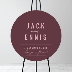 Round shape flat lay of Never Let You Go wedding welcome sign featuring bold and delicate typography with modern, expressive layout and semi-custom design.